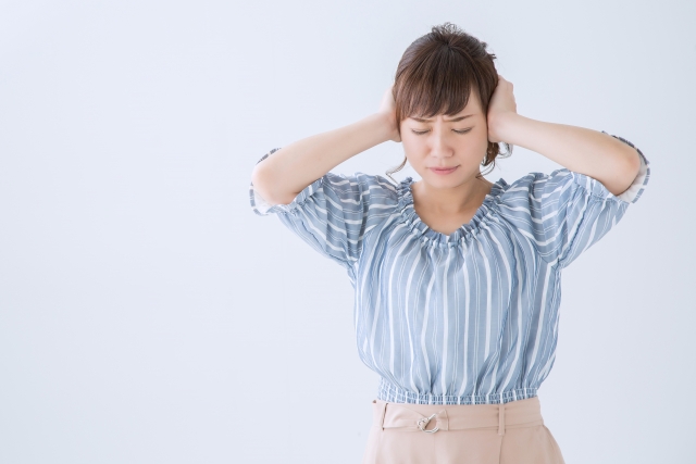 耳をおさえる女性